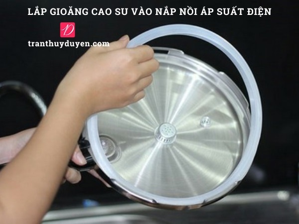 Lắp gioăng cao su vào nắp nồi áp suất điện